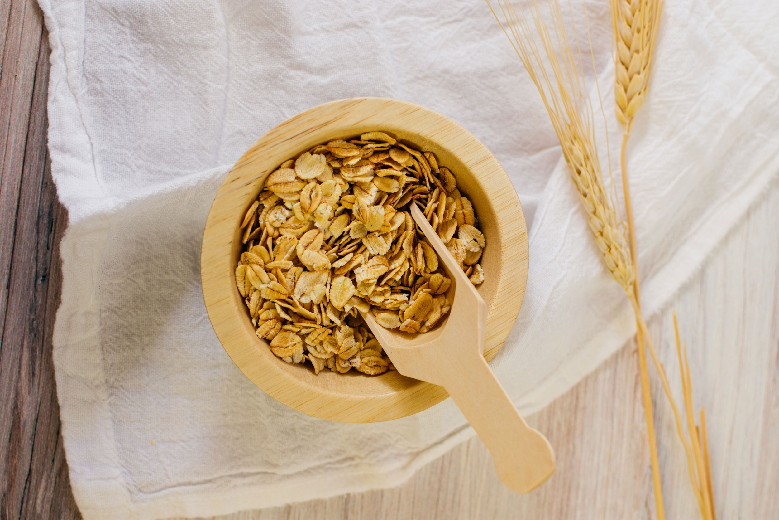 Image of a bowl of oatmeal with a wooden spoon scooping into it