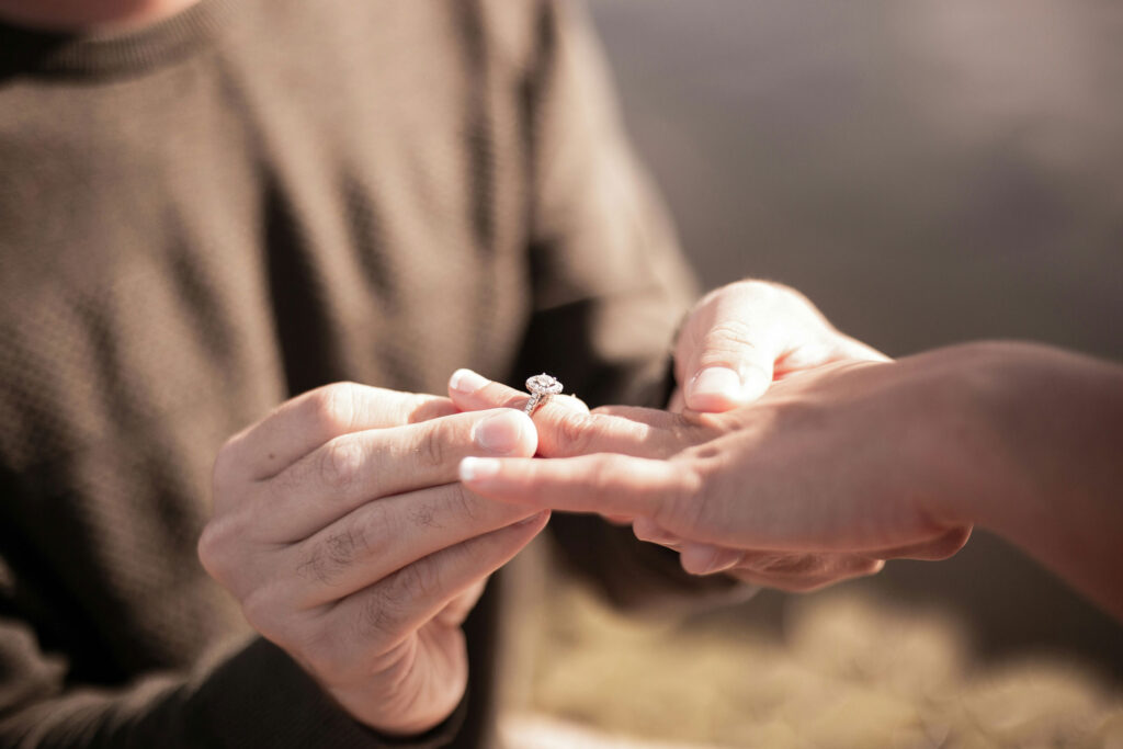 Image of a person putting an engagement ring on another person