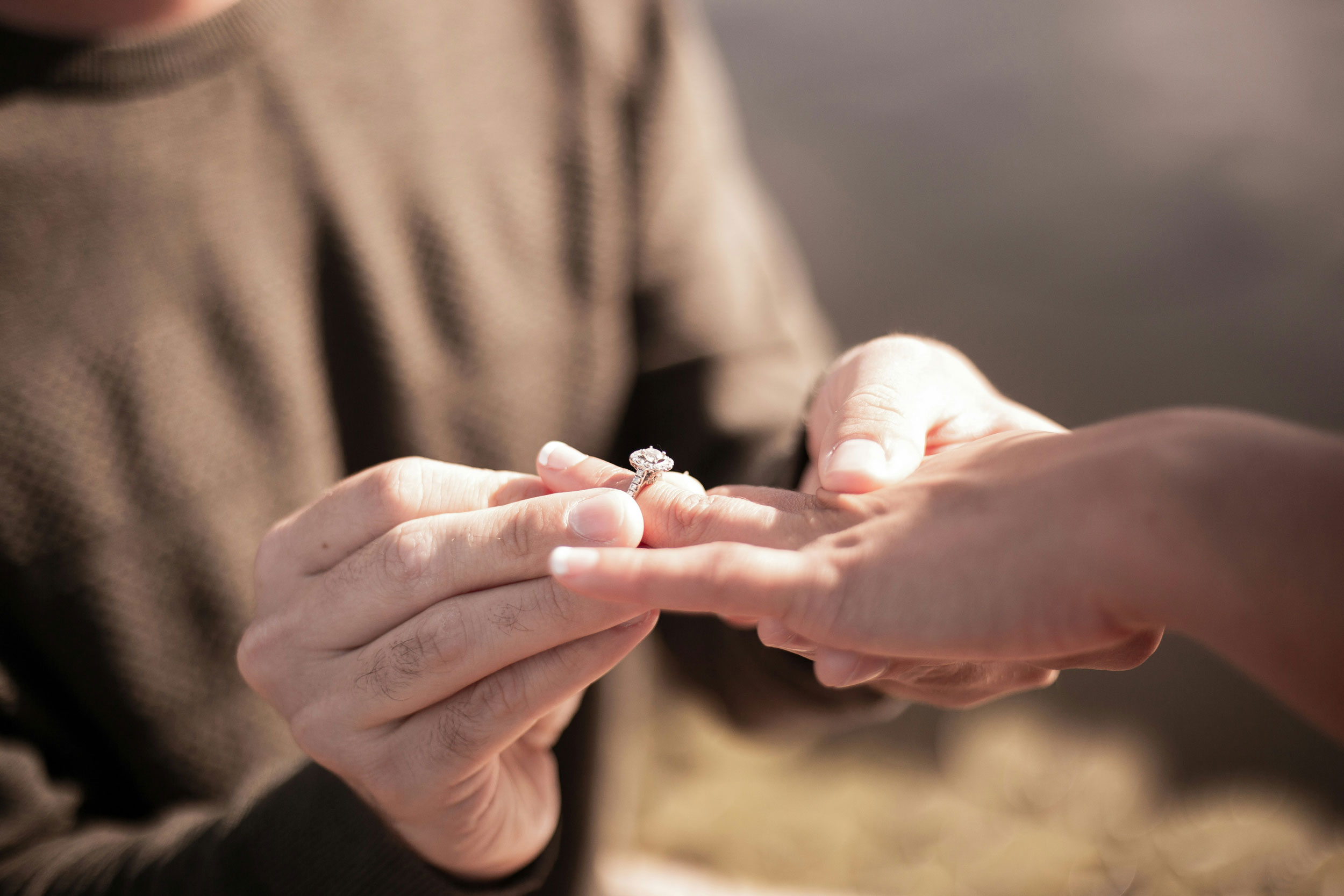 Image of a person putting an engagement ring on another person